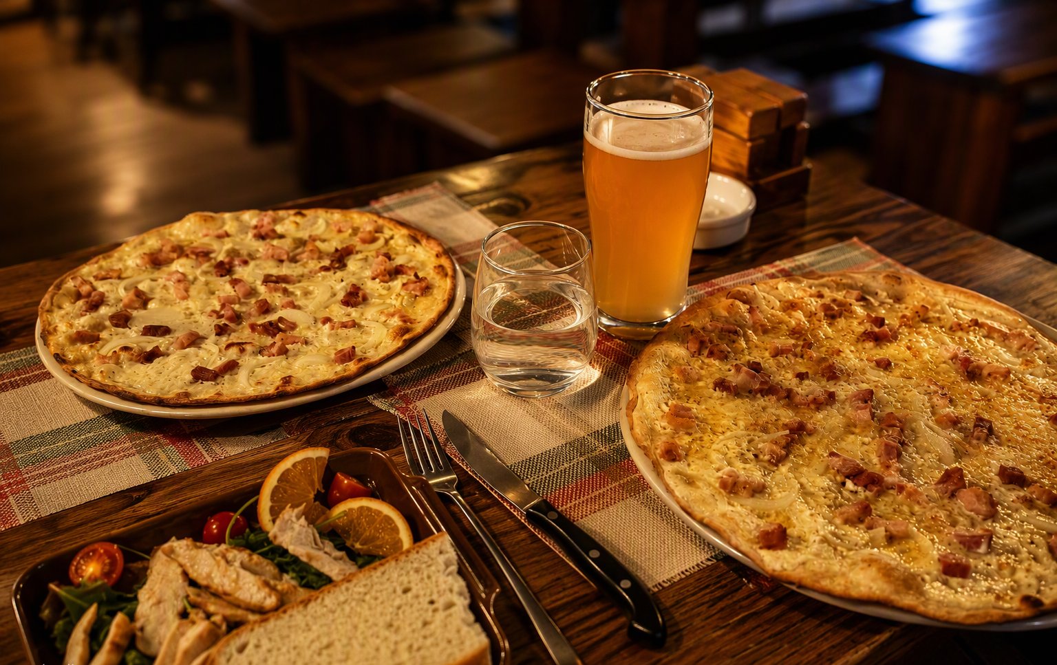 Le pizze e la birra alla spina sul tavolo di legno